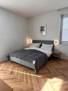 a bedroom with a large bed and a wooden floor at Heimathafen Wiek in Wiek auf Rügen 
