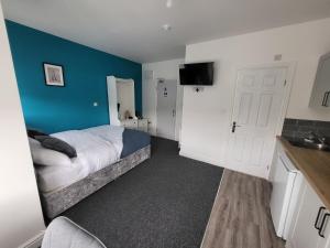 1 dormitorio con cama y pared azul en Stay Sleep Rest - Alfreton Road en Nottingham