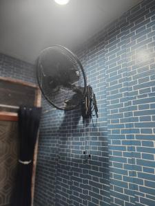 a blow dryer is attached to a blue tiled shower at 108 Quiet and Cozy apartment w/free Wi-Fi in Bangkok