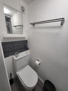 a white bathroom with a toilet and a mirror at Stay Sleep Rest - Alfreton Road in Nottingham