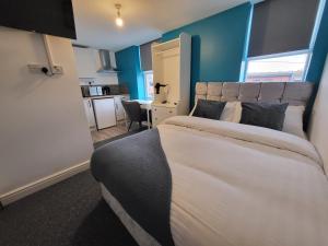 a bedroom with a large bed and a kitchen at Stay Sleep Rest - Alfreton Road in Nottingham