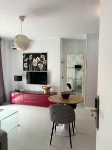Apartamentos Abril في نيرخا: غرفة معيشة مع طاولة وغرفة نوم
