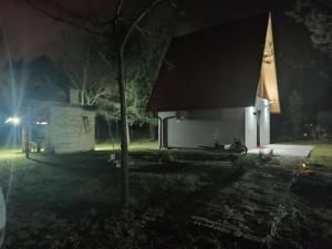 a church at night with a tree in front of it at Vikendica Kelebija in Subotica