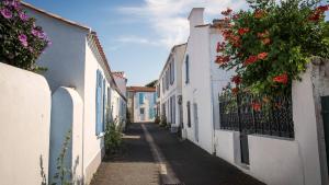a narrow alley with white buildings and flowers on the fence at Le Boisvinet in Saint-Gilles-Croix-de-Vie