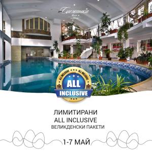 un centre commercial intérieur avec une grande piscine dans un bâtiment dans l'établissement Snezhanka Hotel Pamporovo - All inclusive, à Pamporovo