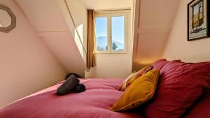 a bedroom with a red bed with a window at Le Monné - Gîte tout confort in Campan