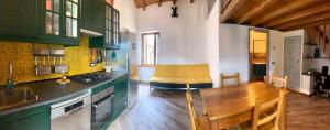 una cucina con armadi verdi e piano di lavoro in legno di La casa di nonna Anita ad Abbadia Lariana