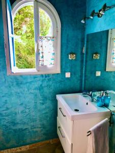 un bagno blu con lavandino e finestra di Sea View Apartment in the Greek Nature a Gouviá