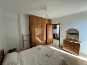 um quarto com uma cama, uma cómoda e um espelho em Comfort Apartments Promenade em Saranda
