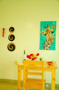 drewniany stół z obrazem żyrafy na ścianie w obiekcie Karisimbi Cave Resort w mieście Ruhengeri