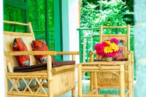 two chairs and a vase of flowers on a porch at Karisimbi Cave Resort in Ruhengeri