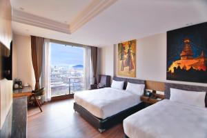 una camera d'albergo con due letti e una grande finestra di Lakhey Hotel a Kathmandu