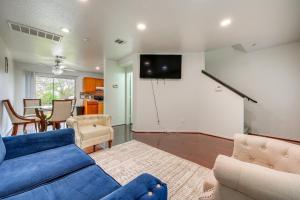 sala de estar con sofá azul y TV en Charming Family Home with Yard - 11 Mi to San Marcos, en Kyle