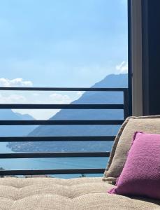 um sofá com vista para o mar a partir de uma janela em Lake Como Ti Amo near Bellagio em Nesso