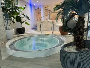 a hot tub with a palm tree in a room with plants at Rafayel Hotel & Spa in London