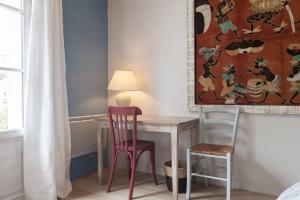 a table and two chairs in a room with a painting at Studio with a terrasse in Floirac