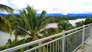 a white fence with a view of a river at Mahaweli View Inn in Kandy