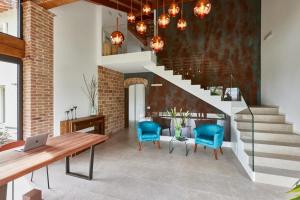 uma sala de estar com uma escada e cadeiras azuis em CasaMartini Bed & Breakfast em Fonte