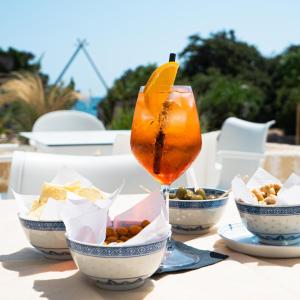 uma bebida sentada numa mesa com tigelas de comida em Hotel dei Bizantini & Villaggio Campo dei Messapi em San Pietro in Bevagna
