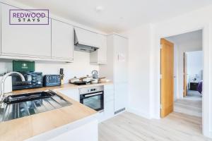 a kitchen with white cabinets and a sign that reads renovated stays at Modern Serviced Apartments For Contractors & Families with Free Parking, WiFi & Netflix By Redwood Stays in Basingstoke +45 photos