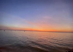 a sunset over a large body of water at เดอะซันเซ็ท บางแสน in Chon Buri