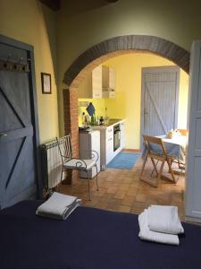 a kitchen with an archway and a table and chairs at Casale del Rosmarino - Monolocale Melograno in Montefiascone