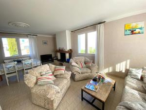 a living room with two couches and a table at Maison au calme et a 2 pas de la plage in Saint-Gilles-Croix-de-Vie