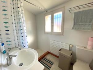 a bathroom with a sink and a toilet and a window at Maison au calme et a 2 pas de la plage in Saint-Gilles-Croix-de-Vie
