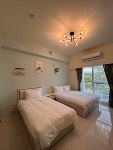 a bedroom with two beds and a chandelier at 近台東火車站 樂典 樂欣 配合補助 包棟 自由行 有車位 in Taitung City