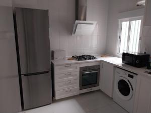 a white kitchen with a stove and a refrigerator at La Iniciativa 2: La luz y El camino in Madrid
