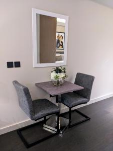 einen Tisch und zwei Stühle in einem Zimmer mit Spiegel in der Unterkunft Soho Mandarin in London