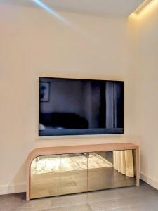 ein Wohnzimmer mit einem TV an der Wand in der Unterkunft Soho Mandarin in London