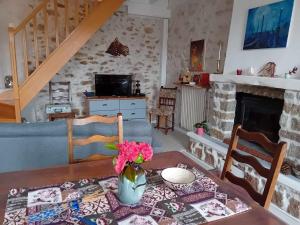 - un salon avec une table et une cheminée dans l'établissement Gîte Sèvremoine Bois Buteau, à Montfaucon