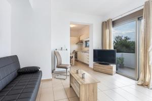 a living room with a couch and a television at Iriana's Apartments in Center in Chania