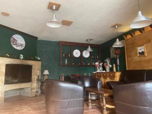 a restaurant with leather chairs and a fireplace at Hôtel La Redoute in Les Rousses