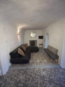 uma sala de estar com um sofá e uma cadeira em The Crystal Cave em Zújar