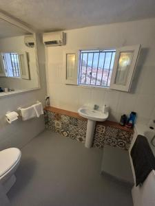 La salle de bains est pourvue d'un lavabo, de toilettes et d'une fenêtre. dans l'établissement The Crystal Cave, à Zújar