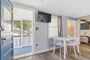 Pokój ze stołem i krzesłami oraz sypialnią w obiekcie The Beaches Guestrooms and Cottages w mieście Wells