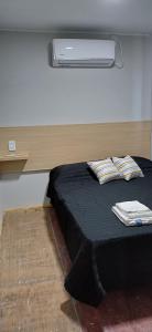 a bed with two pillows on it in a room at Alojamientos Dulce Luz in Villa Elisa
