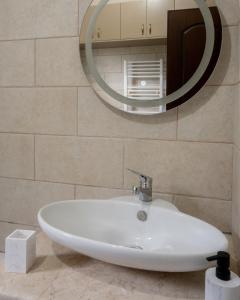 lavabo blanco en el baño con espejo en Verano Family House en Voútai