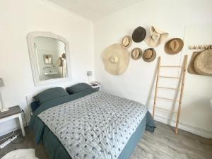 una camera da letto con un letto con uno specchio e cappelli sul muro di Les Vagues a Saint-Gilles-Croix-de-Vie Altre 11 foto