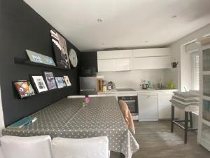 una cucina con tavolo e una cucina con armadietti bianchi di Les Vagues a Saint-Gilles-Croix-de-Vie
