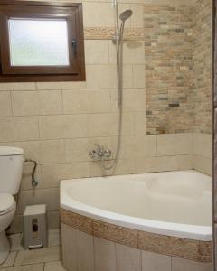 a bathroom with a bath tub and a toilet at Verano Family House in Voútai