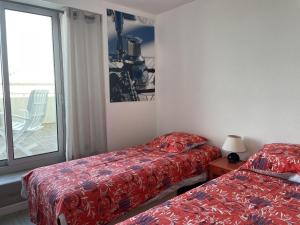 Cette chambre comprend 2 lits et une fenêtre. dans l'établissement Splendide roof top au pied de la grande plage, à Saint-Gilles-Croix-de-Vie