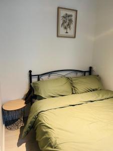 Una cama en un dormitorio con una mesa al lado. en LE CAUBOUS Plein centre T2 calme avec chambre, balcon et cuisine équipée en Bagnères-de-Bigorre