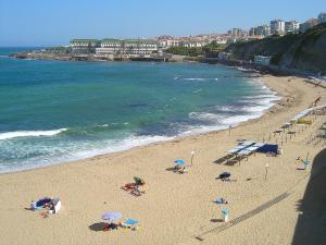a group of people on a beach with umbrellas at Casa Da Avó in Ericeira +7 photos