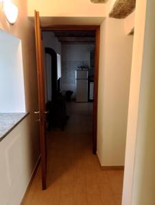 un couloir avec une porte s'ouvrant sur une cuisine équipée d'un réfrigérateur. dans l'établissement Le vigne, à Asti