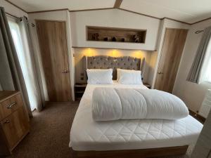 a bedroom with a large white bed with two pillows at Lapwing 60, Scratby - California Cliffs, Parkdean, sleeps 6, bed linen and towels included, no pets in Great Yarmouth
