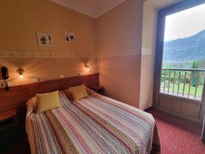 een slaapkamer met een bed en een groot raam bij Hotel Bellevue in Ayse