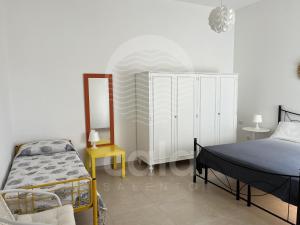 a bedroom with a bed and a table and a bed at Casa Mireya - Spiaggia a 50m - by Cala Salento in Porto Cesareo